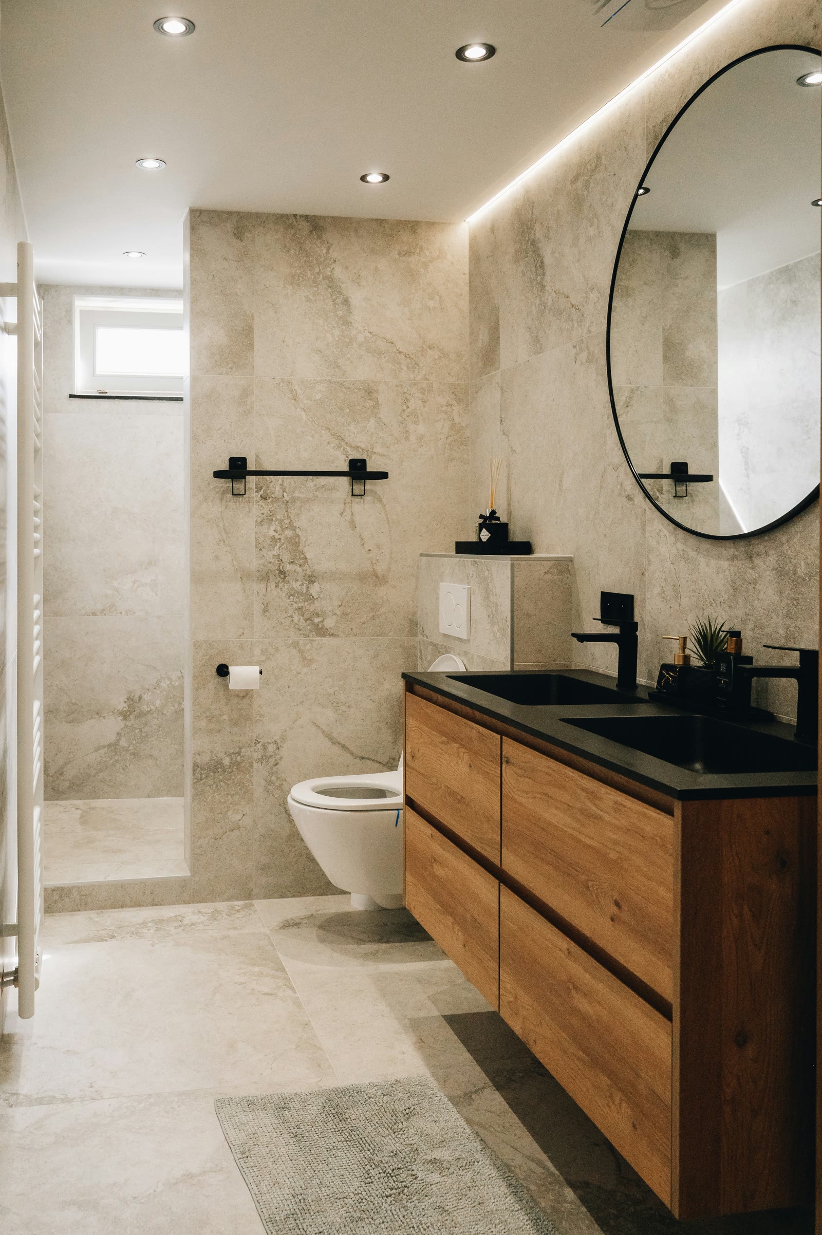 Clean bathroom with wood vanity and tiled shower