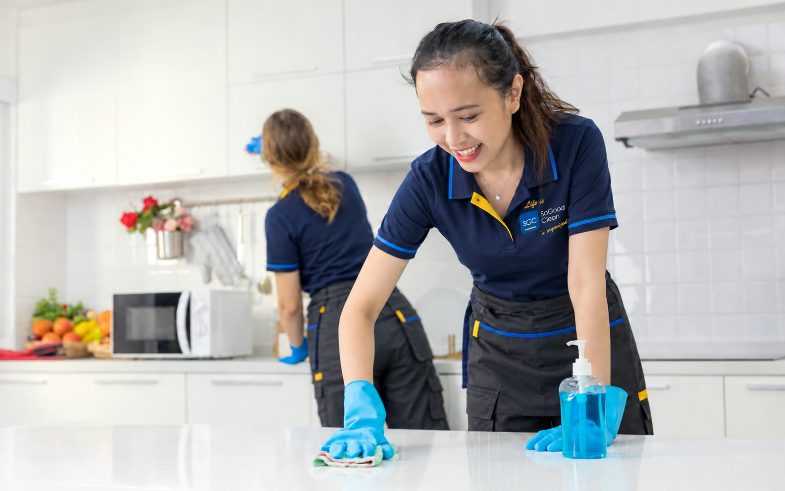 Two uniformed cleaners working in a commercial space