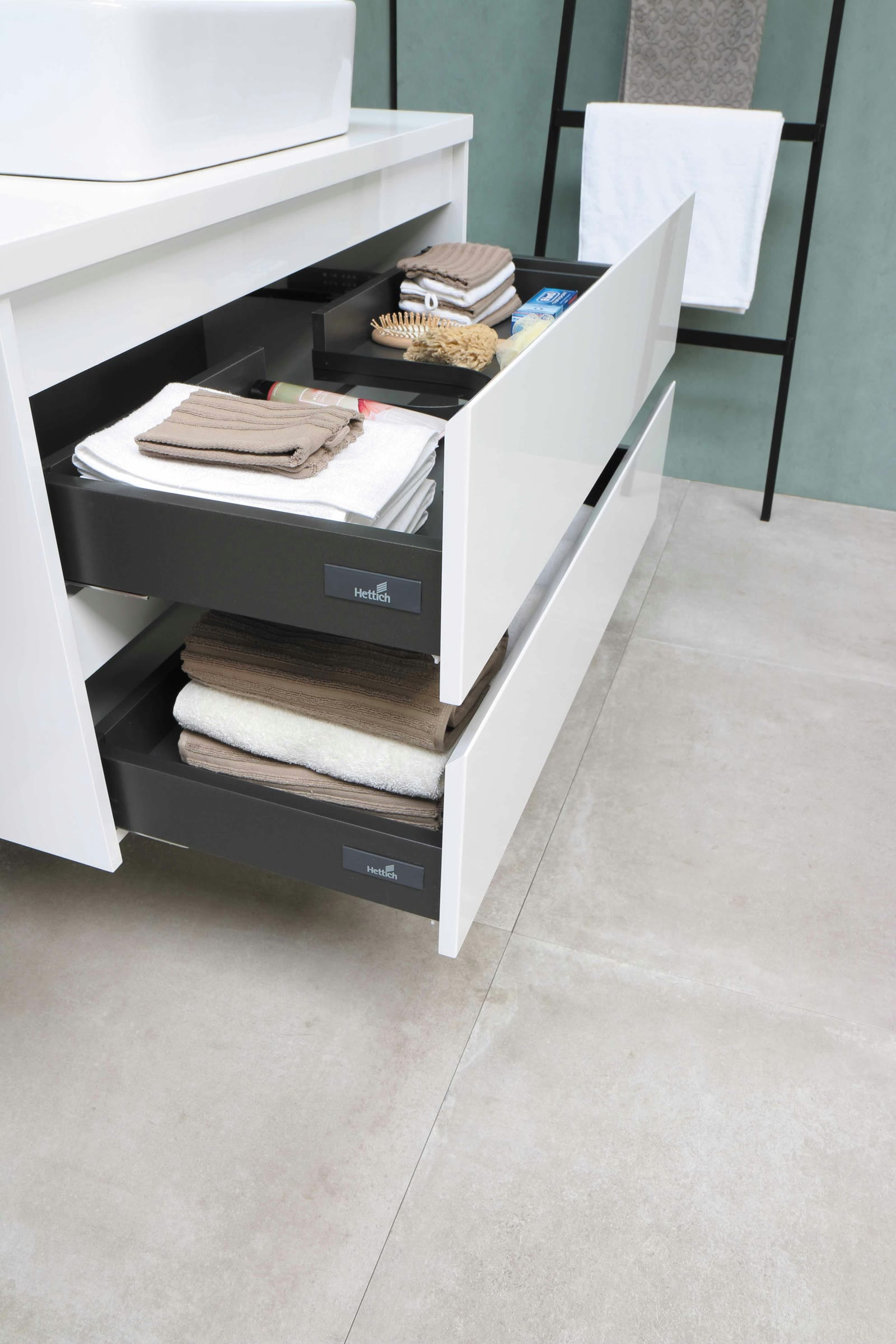 Bathroom vanity drawers with towels and supplies arranged for organization